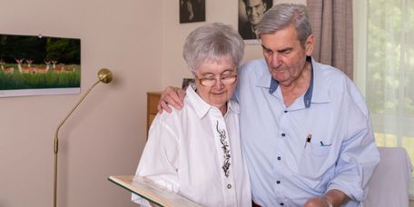 Älteres Ehepaar blätter gemeinsam in einem Fotoalbun