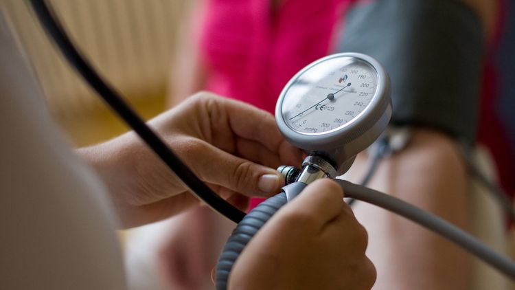 Pflegekraft misst Blutdruck eines Patienten