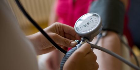 Pflegekraft misst Blutdruck eines Patienten